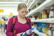 Young mother shoping juices in supermarket