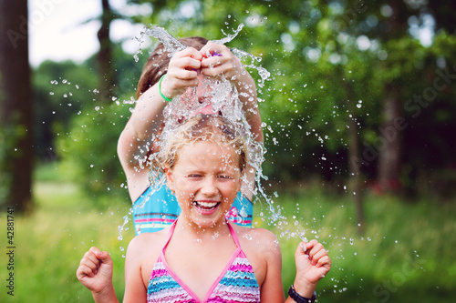 Foto: girls having fun outdoor with water balloons girls having fun outdoor with water balloons