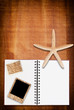 Photo: Star fish and notebook on the wood texture. Star fish and notebook on the wood texture.