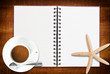 Photo: Star fish and notebook on the wood texture. Star fish and notebook on the wood texture.