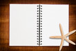 Photo: Star fish and notebook on the wood texture. Star fish and notebook on the wood texture.