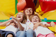 Mother and her daughters having fun on jumping castle