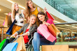 Four female friends shopping in a mall with wheelchair