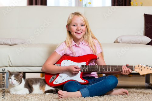 Foto: Child with guitar making music Child with guitar making music
