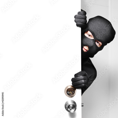 Photo: Home burglar opening house door with copyspace Home burglar opening house door with copyspace