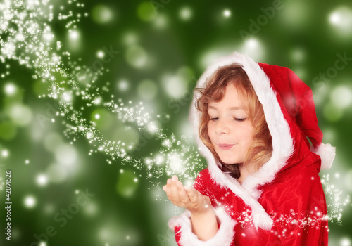 Photo: Kleine Miss Santa mit Sternenstaub vor grünem Hintergrund Kleine Miss Santa mit Sternenstaub vor grünem Hintergrund