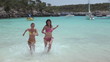 Two female friends running out of water, slow motion