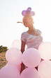 Photo: girl surrounded by balloons by the rays of sunlight girl surrounded by balloons by the rays of sunlight