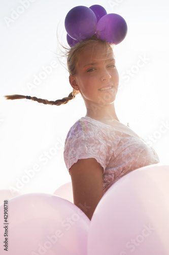 Photo: girl surrounded by balloons by the rays of sunlight girl surrounded by balloons by the rays of sunlight