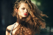 Foto: Beautiful young woman with gorgeous curly hair outdoors Beautiful young woman with gorgeous curly hair outdoors