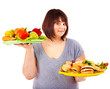 Woman choosing between fruit and hamburger.