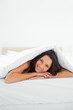 Attractive woman under the duvet 