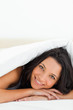 Close-up of a woman with green eyes under the duvet