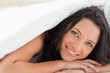 Attractive woman with green eyes under the duvet