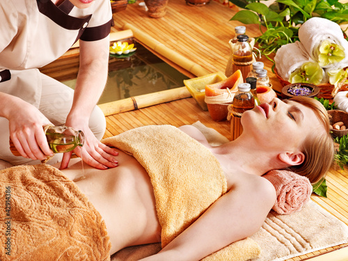 Foto: Woman getting massage in bamboo spa. Woman getting massage in bamboo spa.