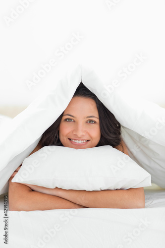Photo: Close-up of a cute woman hugging a pillow Close-up of a cute woman hugging a pillow