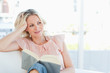 Cute woman lying on a sofa with a book