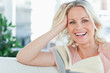 Blonde female laughing with a book