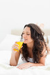 Attractive brunette drinking an orange juice