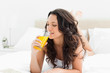 Attractive brunette drinking a fruit juice