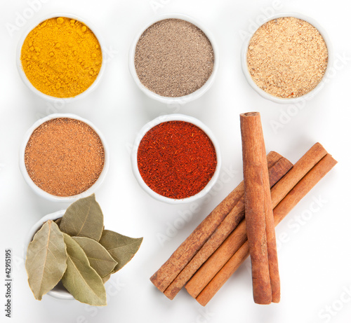 Photo: Different spices in white bowls isolated on white background. Different spices in white bowls isolated on white background.