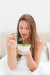 Close-up of a pretty woman eating a bowl of salad