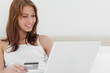 Redheaded on her bed using her credit card online