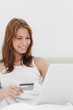 Redheaded sitting on her bed while shopping online