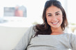 Portrait of a beaming woman lying on her divan