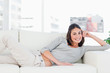 Portrait of a happy brunette on her sofa 