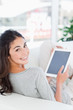 Portrait of a smiling brunette using a touchpad