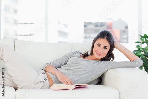 Photo: Portrait of a brunette reading on her sofa Portrait of a brunette reading on her sofa