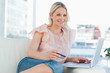 Smiling blonde buying online with a laptop