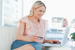 Happy blonde buying online with a laptop