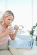 Blonde on a laptop with a coffee