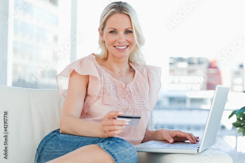 Photo: Portrait of a blonde buying online with a laptop Portrait of a blonde buying online with a laptop