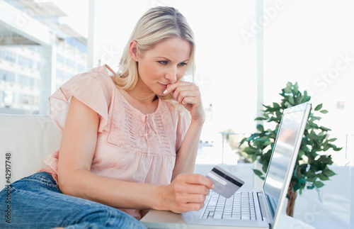 Photo: Blonde thinking to shop online Blonde thinking to shop online