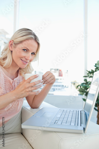 Photo: Blonde on a laptop with a coffee Blonde on a laptop with a coffee