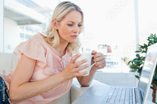 Photo: Blonde on a laptop with a tea Blonde on a laptop with a tea
