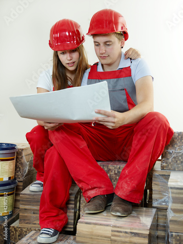 Foto: Young worker fixing up a house, sitting in a building lot Young worker fixing up a house, sitting in a building lot