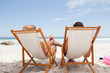 Rear view of a young couple sitting on deck chairs