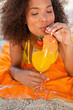 Young relaxed woman closing her eyes while sipping a fruit cocktail