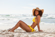 Photo: Side view of a young woman sitting in front of the ocean Side view of a young woman sitting in front of the ocean