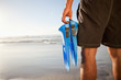 Rear view of a man holding fins