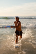 Young man running in the water while smiling