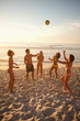 Young people in swimsuits playing with a beach ball