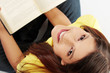 Student girl with book is smiling and looking up.