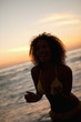 Young woman standing in front of the sea while smiling