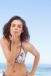 Woman blows a kiss as she rests her hand on her hip
