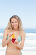 Woman looking ahead and smiling as she holds a cocktail